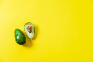 Wall Mural - A few sliced avocados on a yellow background. Top view, flat lay, space for text