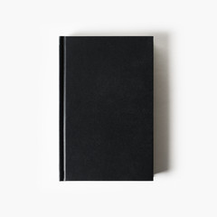 Wall Mural - Blank black booklet. Vertical book cover on white paper background. Flat lay.