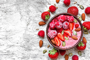 Wall Mural - Smoothie bowl with red berries - strawberry and frozen raspberry, nuts and seeds. healthy breakfast