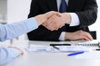 © rogerphoto - Close Up of unknown business people shaking hands while finishing up a meeting. Handshaking, agreement or success concept in people communication