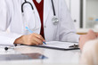 © rogerphoto - Close up of a female doctor filling up  an application form while consulting patient