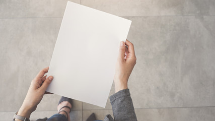 Person holding white empty paper