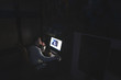 © bodnarphoto - A man is sitting at home in a dark room and uses the internet on a computer. Work at a computer at home. Night snack.