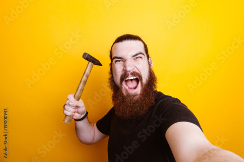 Angry bearded man with hammer making selfie Tableau sur Toile