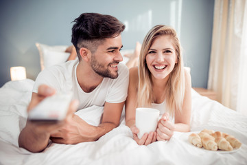 Wall Mural - Happy man and woman having breakfast in bed