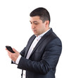 © k_samurkas - Portrait of a young man dressed in a white shirt and black suit looking at a mobile phone. Isolated on white