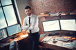 Young male trader at office work concept standing smiling confident