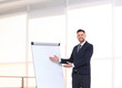 © New Africa - Young business trainer near flip chart, indoors