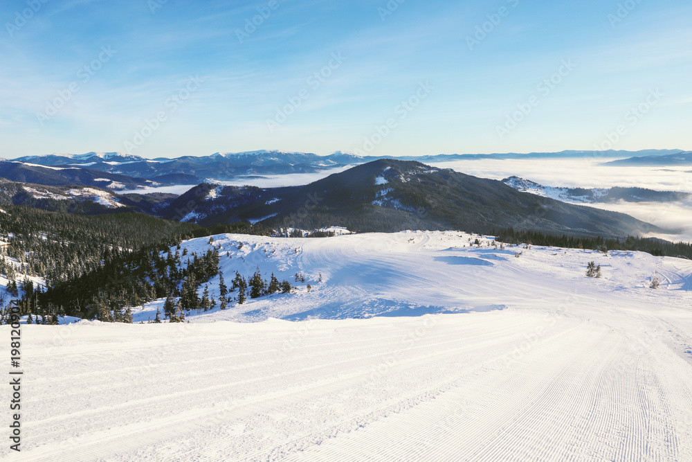 Ski slope at snowy resort on winter day