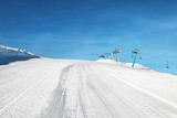 Fototapeta Natura - Ski piste with aerial ropeway at snowy resort. Winter vacation
