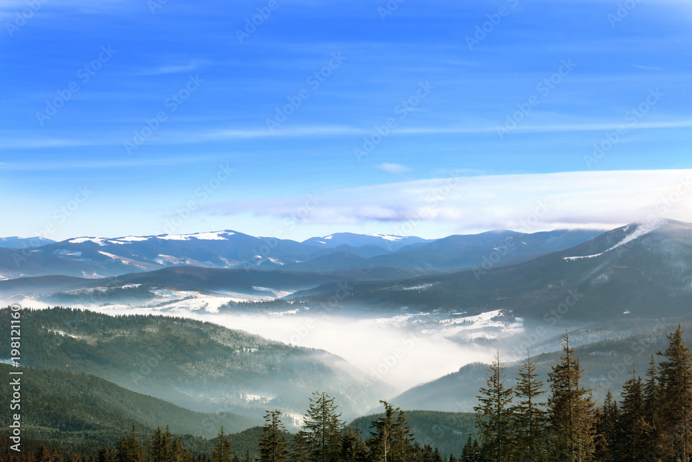 Beautiful landscape with foggy mountains in wintertime