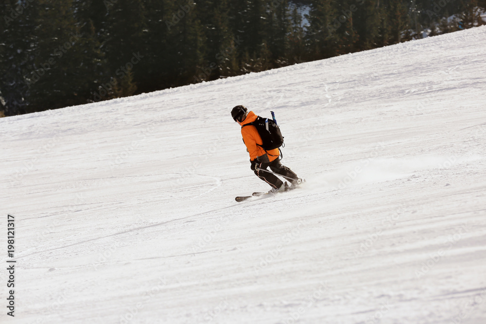 Sportsman skiing downhill at snowy resort. Winter vacation