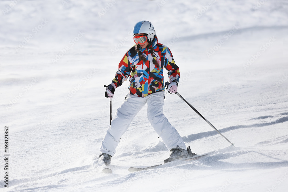 Woman skiing on piste at snowy resort. Winter vacation