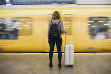 Rear View Of A Blond Woman Waiting At The Train Platform