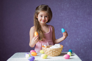 Wall Mural - The girl is surprised and plays with colorful eggs.