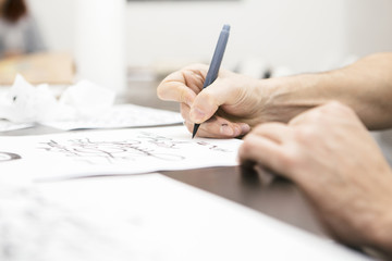 Woman make calligraphy writings, make art on a paper using pen brush and sign pen. Adult, old hands of a calligrapher man. Lifestyle image of a design process