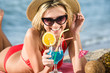 © illustrissima - woman on the beach drinks coktail