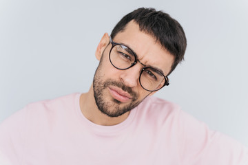 Sticker - Closeup self portrait of serious macho man wears trendy round glasses and pink clothes posing isolated over white background in studio wall. People, lifestyle and emotion concept.