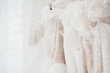 Wedding dresses for bride on hangers against white background loft store. Concept wedding, engagement, attributes, clothing, love.