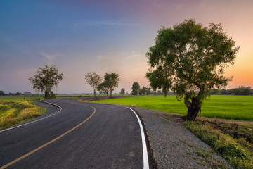 sunset in clouds with sunrays over road to horizon