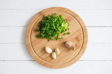 Scallions garlic ginger cutting board wooden background.