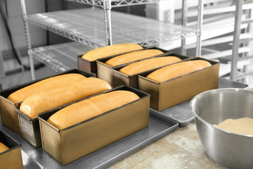 Wall Mural - Loaf tins with fresh bread in bakery