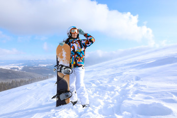 Wall Mural - Female snowboarder on ski piste at snowy resort. Winter vacation