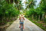 woman on a bicycle crosses vanilla plantations, dique island, se