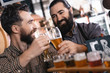 © freeograph - Happy bearded men try beer of different styles in beer samplers in brewery of craft beer.