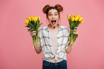 Wall Mural - Portrait of an excited young girl holding yellow tulips