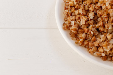 Wall Mural - plate of buckwheat on white wood background. Top view.