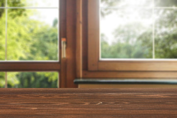 Wall Mural - dark brown wooden table top with copy space and wooden window background.
