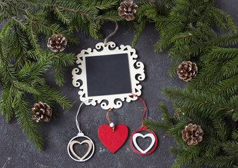 on a festive background a plate for notes, cones, branches of pine and wooden hearts