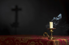 Candle On A Dark Background With The Silhouette Of The Cross.