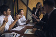 © boonchok - Executives are signing a business deal in the conference room and a young businessman applauds the congratulations.