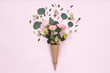 Top view of floral composition of beautiful pink rose flower in kraft cornet on white background, flat lay, copyspace