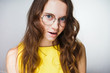 © mnelen.com - beautiful young woman in a yellow dress and glasses posing and looking at the camera