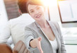 © ASDF - successful business woman stretches out hand for a handshake.