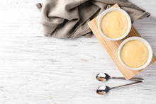 Bowls With Vanilla Pudding On Wooden Background