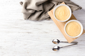 Wall Mural - Bowls with vanilla pudding on wooden background