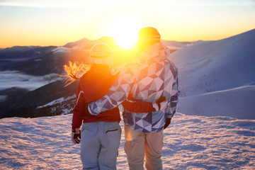 Canvas Print - Couple enjoying the beauty of sunset at snowy ski resort. Winter vacation