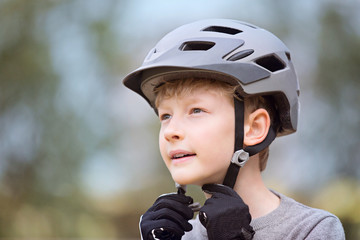 kid putting bike helmet on