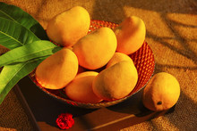 A Decorative Bowl Full With Fresh Alphonso Mangoes, Mango Leaves, Top View