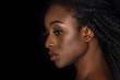 profile portrait of beautiful african american woman with water drops on face looking away isolated on black