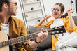 © LIGHTFIELD STUDIOS - young man playing guitar for happy girlfriend