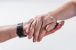 © LIGHTFIELD STUDIOS - cropped shot of senior man and rehabilitation therapist holding hands isolated on grey