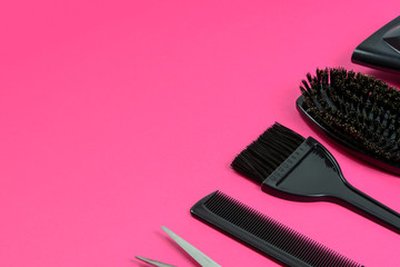 Hairdresser set with various accessories on a pink background with copy space