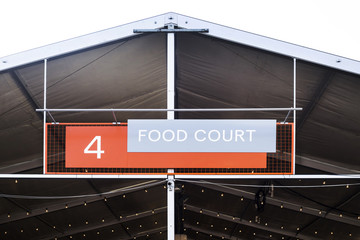 Food court - a large sign above the canopy of a place to feed on open air. Summer entertainment, festival