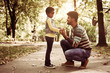 © Mladen - African American father and his daughter talking in park.