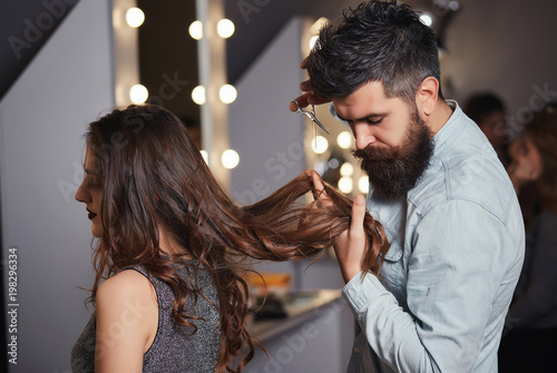 Bearded Male Hairdresser Cutting Clients Hair With Scissors At